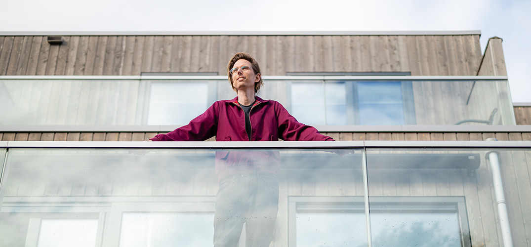 Mart staat op het balkon van zijn nieuwbouwwoning